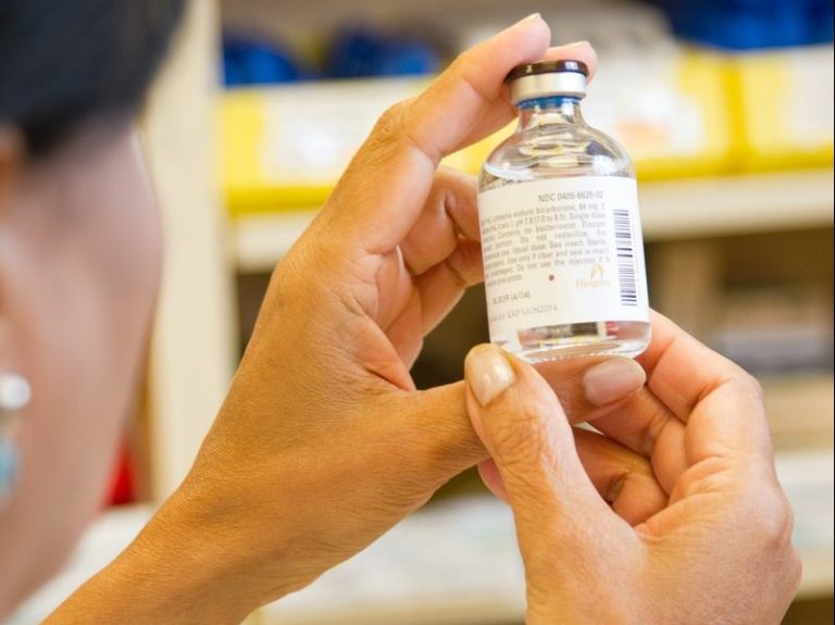 person holding white labeled bottle