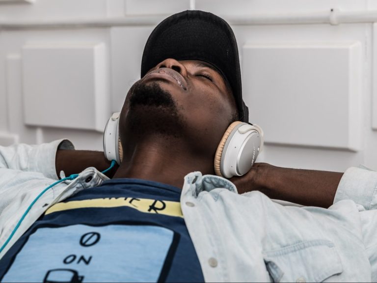 man wearing denim jacket wearing headphones and listening to music