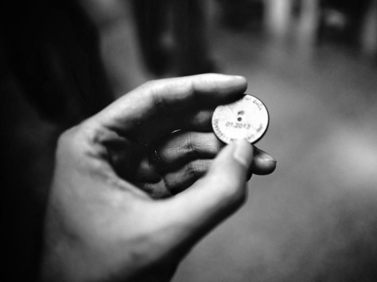 grayscale photography of person holding coin