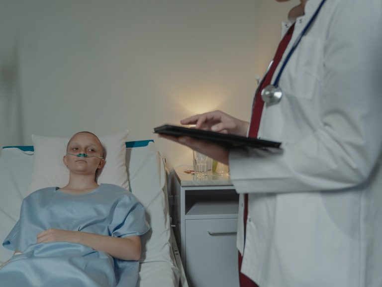 Man in Blue Crew Neck T-shirt Sitting on Hospital Bed