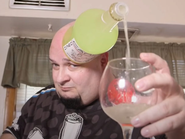 jamie keeton filling a wine glass from a bottle stuck to his head tcm  e
