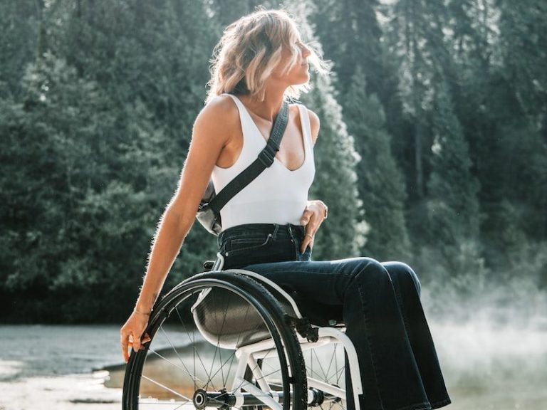 woman riding wheelchair near trees