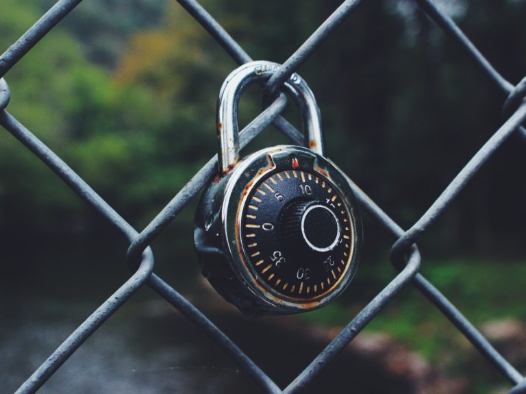 black and gray code padlock anchored on chain-link fence selective focus photo