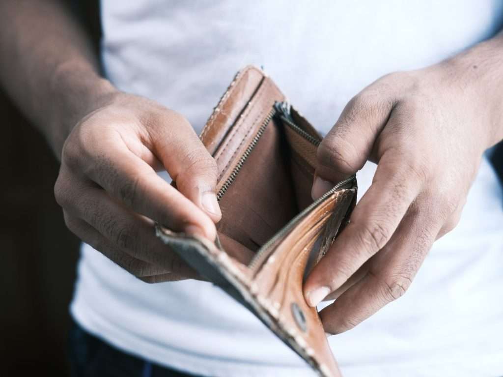 person holding brown leather bifold wallet