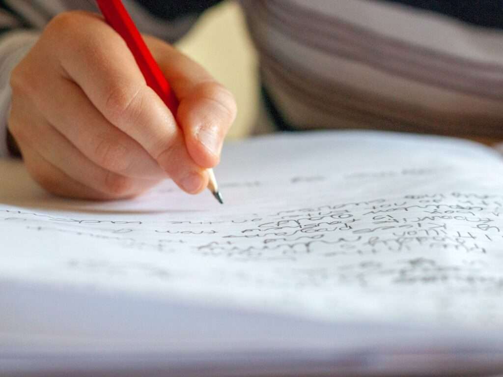 person writing on white paper
