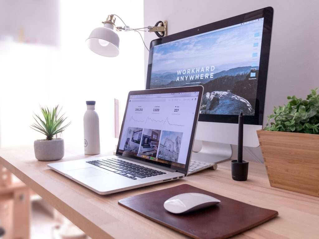 MacBook Pro on table beside white iMac and Magic Mouse