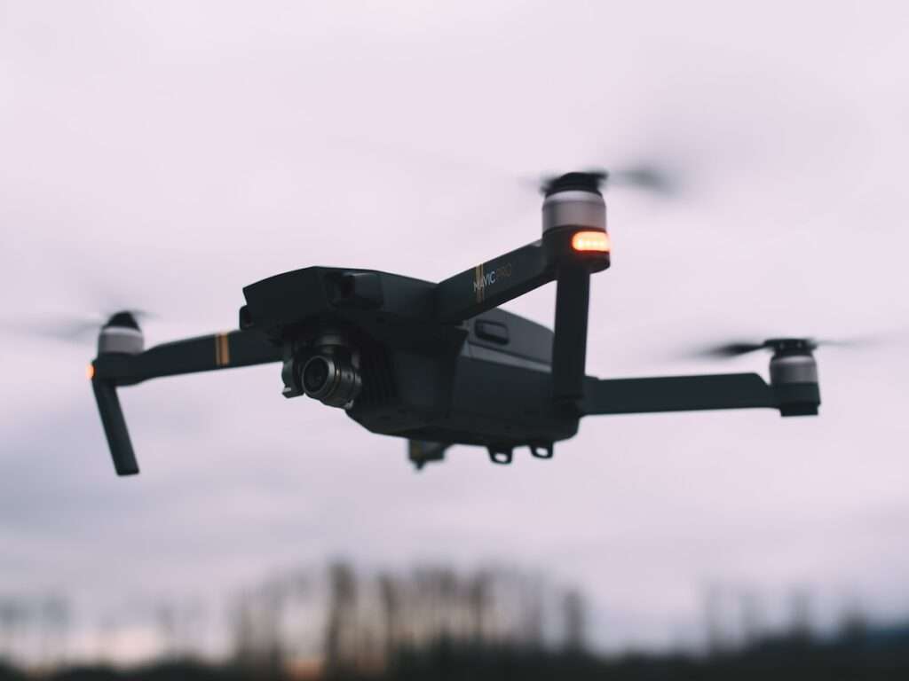 black quadcopter drone hovering in the air
