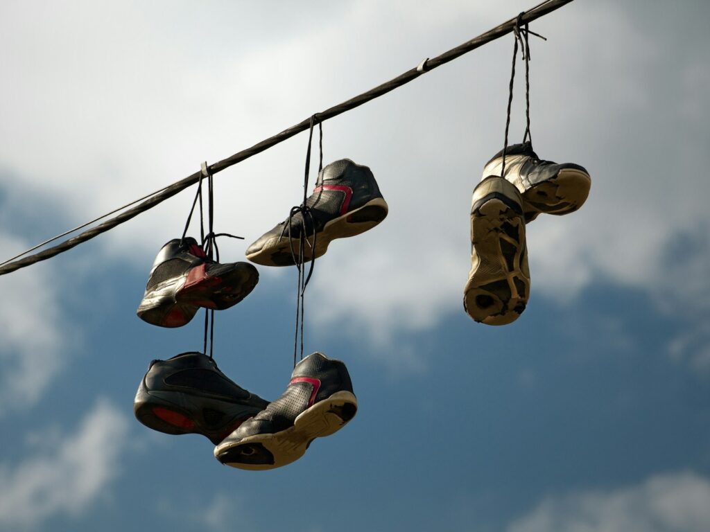 several pairs of shoes hanging from a wire